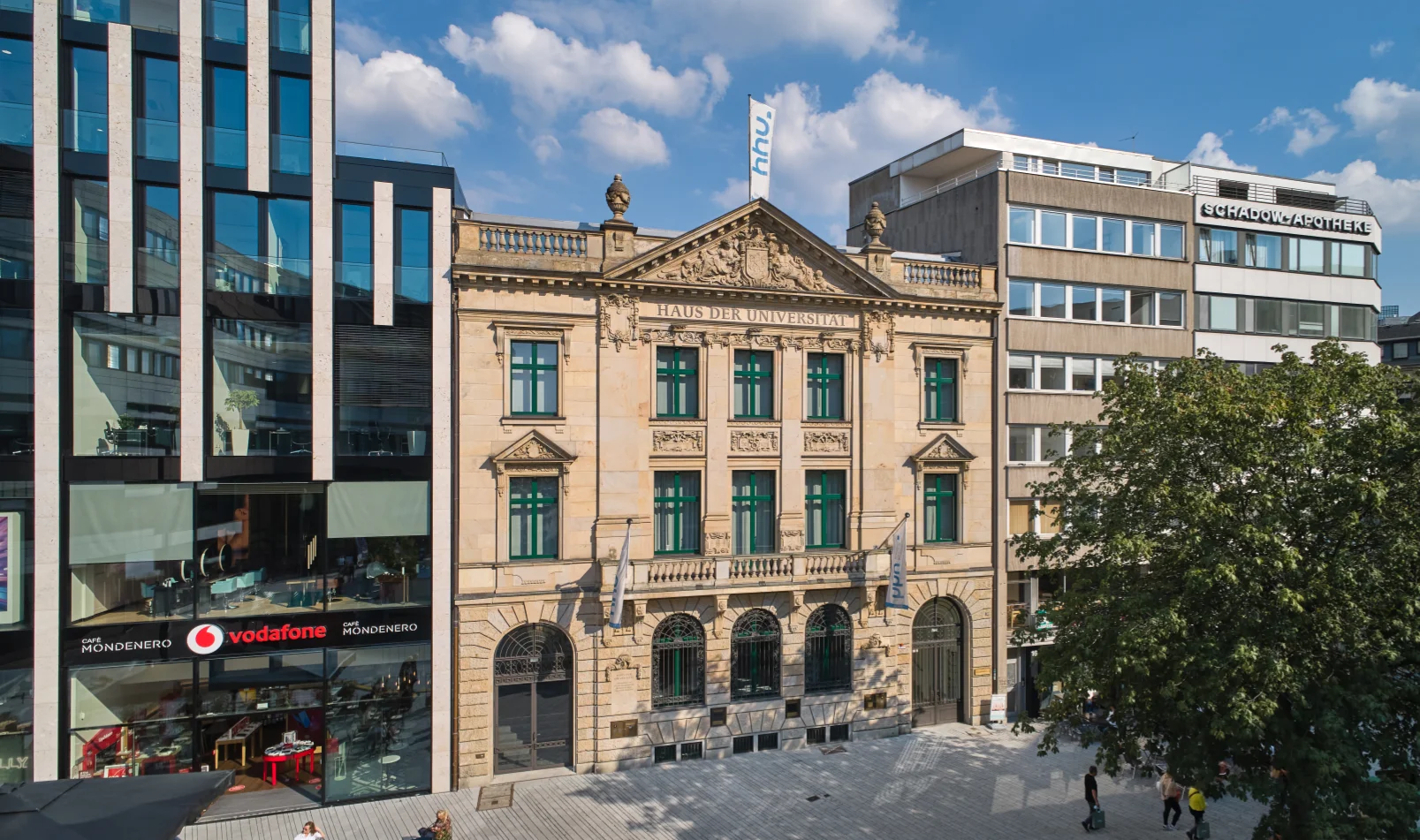 Historische Sandsteinfassade des Haus der Universität neben moderner Glasarchitektur
